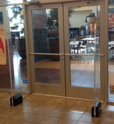 Dual Clear Vector Retail Security Towers (Refurbished), installed flanking a store entrance's double doors