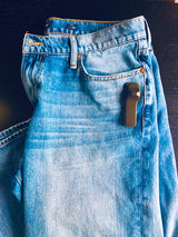 Sensormatic SuperTag I Black - 58KHz, attached to denim jeans near the front pocket