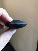 Clam Tag Black (New) - Sensormatic Compatible 58KHz, held in hand showing clamshell edge