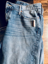 Stylus Tag Gray - Sensormatic Compatible 58KHz, attached to a folded pair of jeans